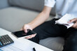 © Charlie's - Man calculate finances home pay bills taxes on mobile phone financial at home