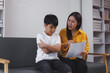 © Phimwilai - Asian mother scolding son for bad grades on report card at home