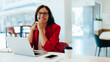 © (JLco) Julia Amaral - Confident businesswoman smiling while working in a bright office environment