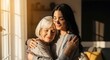 © HD COLLECTION - A young woman tenderly embraces her elderly mother, sharing a moment of love and connection bathed in warm sunlight.