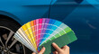 © MUHAMMAD - Choosing the perfect color shade from a palette of paint swatches for a car