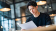 © Velour Rhythm - Focused businessman reading documents in modern cafe
