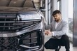 © anatoliycherkas - Arab man inspecting new car in dealership showroom
