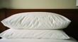 © pansit.me - Stacked white pillows on a bed against a wood headboard