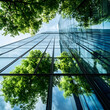 © MDSUVORAHMAN - Modern glass skyscraper reflecting lush green trees and blue sky