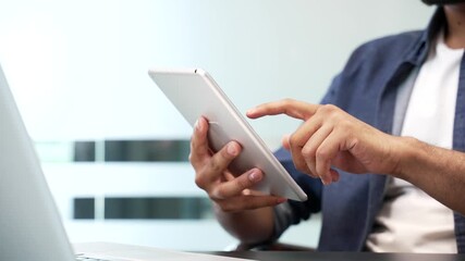 Close up of male hands holding digital tablet at desk at workplace in modern business office. Businessmen using working on application, typing message, chatting, banking or swiping browsing online