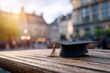 © halawiah - Graduation Cap on Wooden Table, Sunlit Cityscape Background.