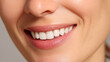 © buraratn - Close up of smiling woman showcasing bright, white teeth and healthy gums, radiating confidence and happiness. soft lighting enhances natural beauty of her smile