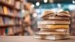© Thanyaporn - Stacked Open Books on a Table with Blurry Library Background