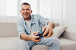 © SHOTPRIME STUDIO - A relaxed man enjoys playing video games at home, showcasing the balance of leisure and digital engagement. This scene highlights modern lifestyle choices.