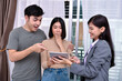 © S photographer - Three professionals engaged in a lively discussion over a tablet.