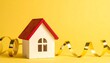 © Ronald - Miniature House on a Vibrant Yellow Background with Festive Gold Ribbon