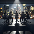 © Veggymulyanto - Silhouetted businesspeople arguing around a table at night.