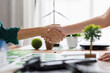 © groviapoto - Close up of business people shaking hands over ESG strategic commitment workshop, SDGs report, global warming, green finance investment eco friendly and net zero waste in boardroom training building.