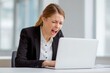 © Serhii - Frustrated Young Businesswoman in Office, Overwhelmed and Emotional While Working on Laptop