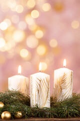 Wall Mural - A beautiful, bright, festive Christmas abstract pink background with lit candles and a bokeh effect. Shining and sparkling, vibrant. Vertical banner, copy space