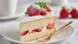 © Endang - A slice of strawberry shortcake, dusted with powdered sugar, sits on a plate with a gold fork, accompanied by fresh strawberries