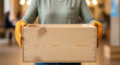 © Aurora Aesthetics - A volunteer in work gloves holds a large empty wooden crate a concept for donations charity drives and community support with copy space on the side of the box