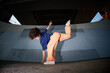 © Seventyfour - Girl breakdancing outdoors under bridge, balancing on one hand with legs extended, curly hair moving, expressing energy and athleticism in urban setting