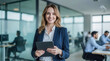 © Sync - Businesswoman holding and using digital tablet in hand and looking with smile face in professional corporate company leader portrait in modern tech office workplace blur background