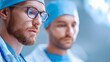 © Margarita Ratatosk - Confident male surgeon with beard, wearing scrubs, glasses, and stethoscope. Focus on modern medicine and healthcare technology.