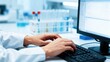 © misu - Scientist working on a computer in a laboratory setting, typing on a keyboard.