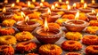 © Nasima Begum - A beautiful arrangement of numerous small clay diyas or oil lamps, each with a lit flame, creating a warm and festive ambiance, often used during celebrations like diwali