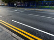 Manchester street scene with double yellow lines white road markings and a blue fence