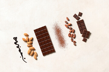 Wall Mural - Sweet chocolate with almond nuts, cocoa beans and powder on white background