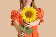 © Pixel-Shot - Beautiful young happy woman with sunflower on beige background, closeup