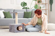 © Pixel-Shot - Mature redhead woman and cute Maine Coon cat in its house at home
