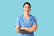 © Pixel-Shot - Tattooed female doctor on blue background