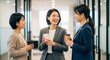 © Stingray_Japan - 同僚との会話：オフィスの廊下で談笑する日本人女性社員たち