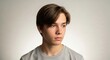 © dals stock - Portrait of a young man looking sideways with a neutral expression against a plain background.