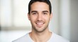 © dals stock - A close-up portrait of a smiling young man with short dark hair and a white t-shirt, looking directly at the camera with a friendly expression.