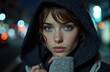© starush - Woman with blue eyes wearing a dark hoodie in an urban night scene