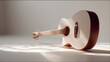 © Vaundy - Acoustic guitar placed on a minimalist white surface, casting soft shadows in a clean studio setup.