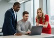 © sujon1638 - Diverse colleagues collaborating enthusiastically around a laptop displaying project success in a modern workspace setting
