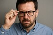 © Татьяна Евдокимова - Portrait of a businessman adjusting his glasses with a serious and intense expression, conveying focus, scrutiny, and determination