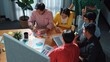 © InfiniteFlow - Group of diverse people brainstorming marketing plan by using sticky note while clapping hands. Top view discussing and talking about stock market investment while working on laptop. Convocation.
