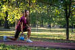© Nenad - Young woman performing kettlebell lunge outdoors at sunset for strength and wellness