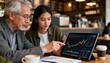 © ubay - Two people in a cafe, examining a financial chart on a tablet.