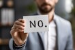 © Best Wishes Art - A Businessman Holding a Card with the Bold Statement 'No' in an Office Setting Reflects Defiance and Assertiveness in Professional Communication