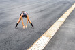 © Carlostock - Middle aged woman bends forward stretching her arms in an outdoor fitness routine, on a wide gray minimalist surface with horizontal copy space.