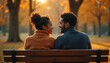© Viktor - Couple sits on park bench, talking outdoors during autumn. Golden sunlight filters through trees. Man, woman share quiet, relaxed moment, fostering connection, companionship. Conversation creates