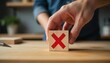 © Umair - Hand poised to press red x on wooden block with a focused determination in a modern workspace, created with generative ai
