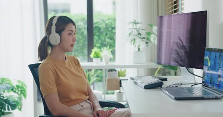 Young Asia female programmer meeting video conference discuss work prompt AI bot IT app program nomad, video game, terminal with coding, user interface, data center on desktop computer at home office.
