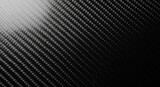 Close up of a black carbon fiber weave texture with light and shadow
