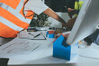 © Natchanida - Closeup of team of industrial engineers meeting analyze machinery blueprints consult project on table in manufacturing factory. Working in manufacturing plant or production plant.