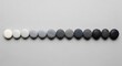 © Arone_Hard47 - Smooth round stones arranged in a color gradient from white to black on a gray background.